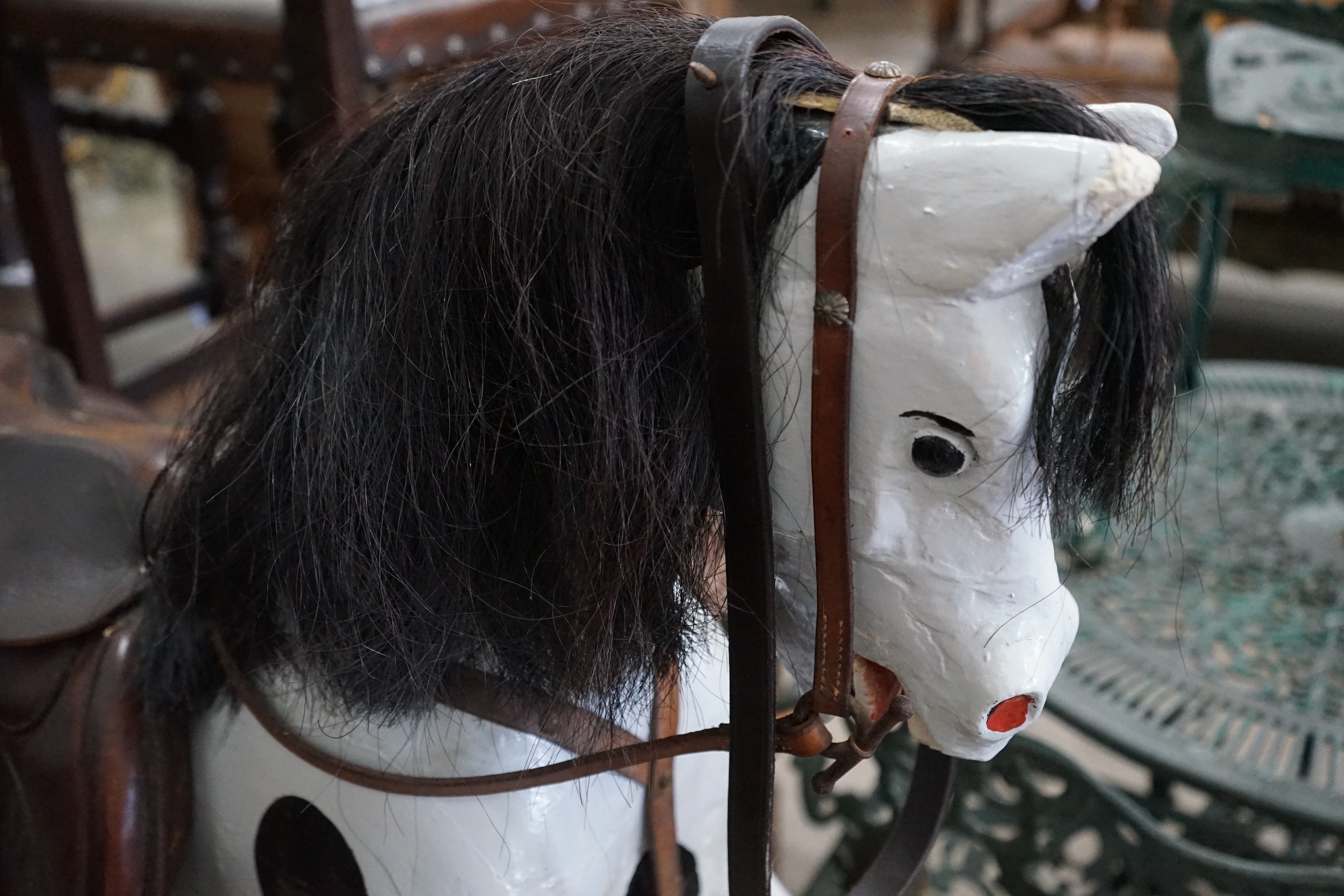 An early 20th century carved wood rocking horse on safety frame (re-painted), height 126cm